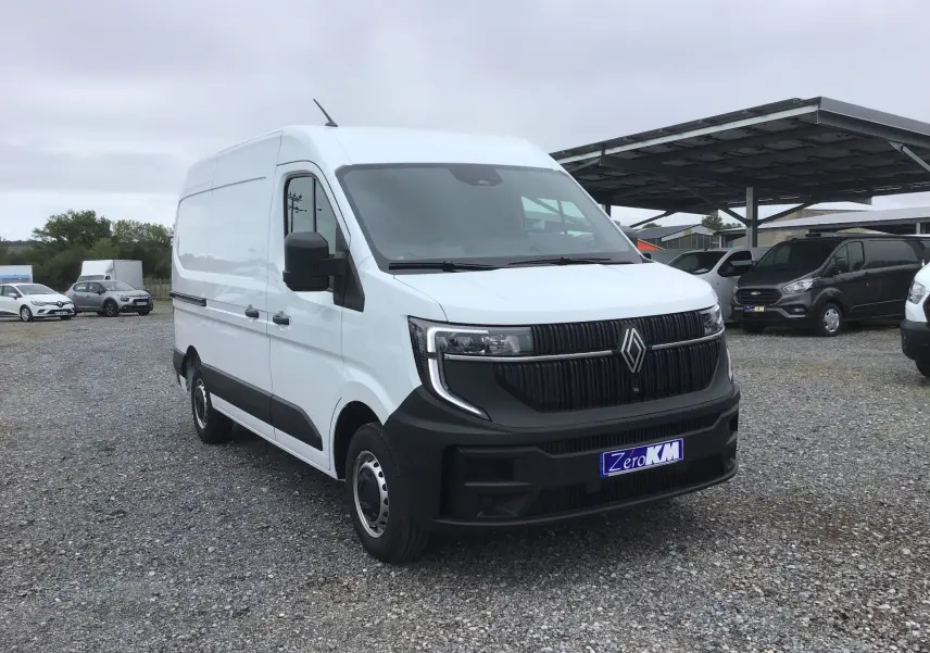 Renault Master blanc en 3/4 avant droit sur parking, avec calandre noire et plaque Zero KM visible.