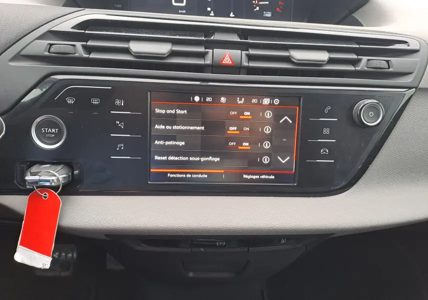 Vue rapprochée de la console centrale noire du Citroën C4 Spacetourer avec écran tactile et bouton Start/Stop visible.