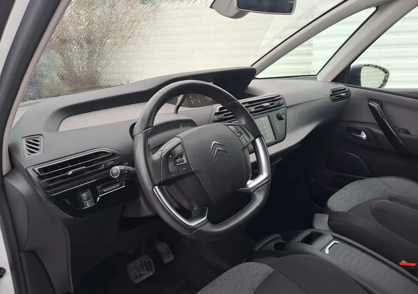 Vue intérieure côté conducteur du tableau de bord et volant noir d'une Citroën C4 Spacetourer blanche de 2018.