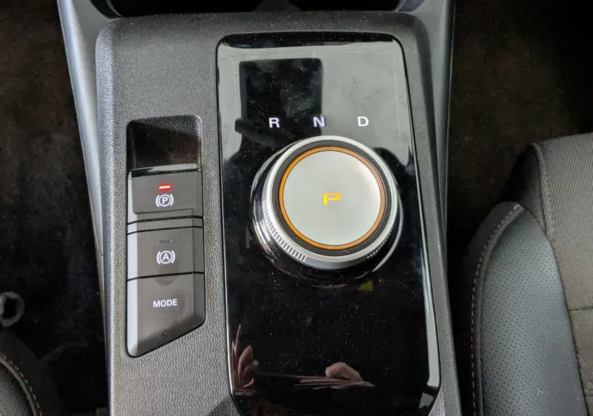 Gros plan sur la molette de sélection de la boîte auto et les boutons de contrôle sur la console centrale noire du MG3 1.5 L Hybrid+ cosmic silver.