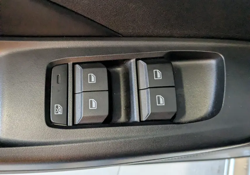Gros plan sur les commandes de lève-vitres noires dans la portière côté conducteur du MG3 1.5 L Hybrid+ cosmic silver.