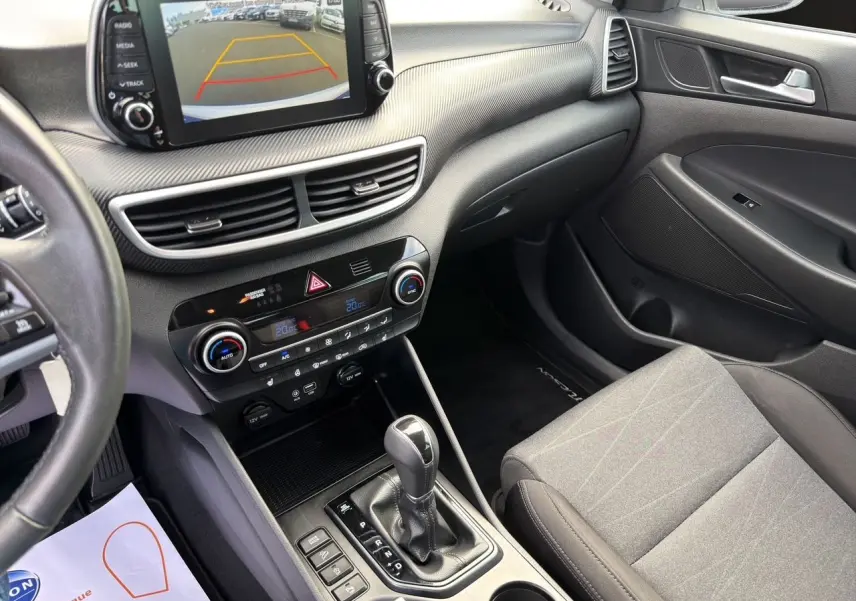 Vue intérieure côté passager du tableau de bord et console centrale du Hyundai Tucson 2020 avec écran tactile et boîte automatique.
