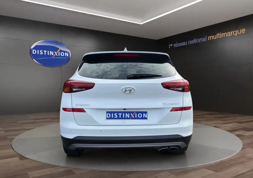 Vue arrière d'un Hyundai Tucson blanc polar 2020 avec feux arrière allongés et double sortie d'échappement.
