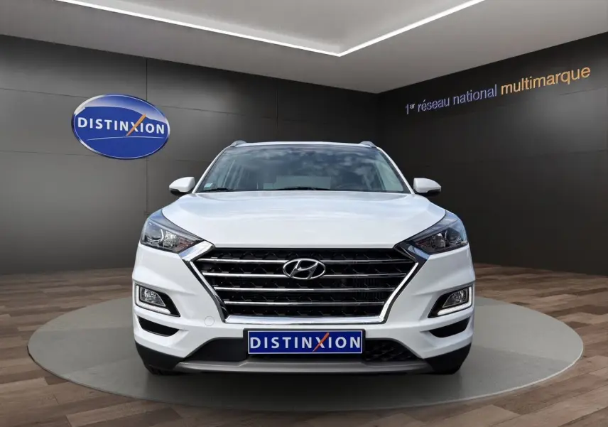 Vue frontale d'un Hyundai Tucson blanc polar 2020 avec calandre noire et logo Hyundai bien visible.