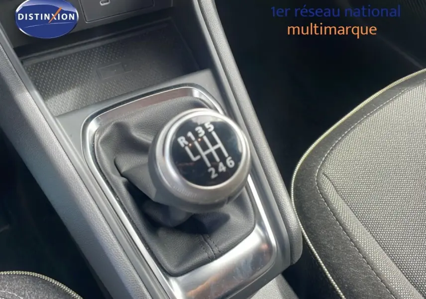 Gros plan sur le levier de vitesses manuel du Renault Captur 2025, intérieur tissu gris avec surpiqûres contrastées.