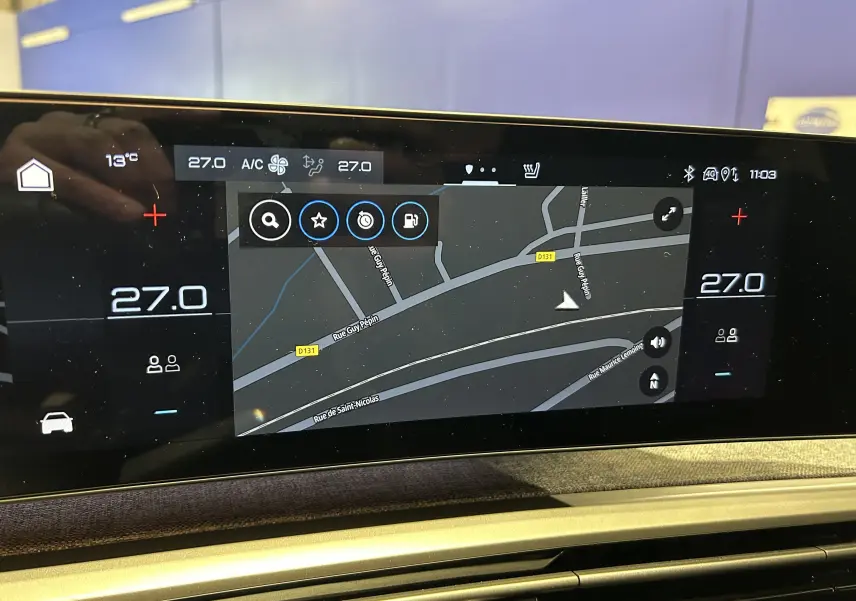 Écran tactile central du Peugeot 3008 Hybrid 2025 affichant la navigation et la climatisation à 27°C.