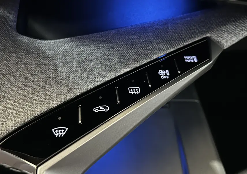 Gros plan sur la commande tactile de climatisation avec éclairage bleu, intérieur tissu gris du Peugeot 3008 blanc.