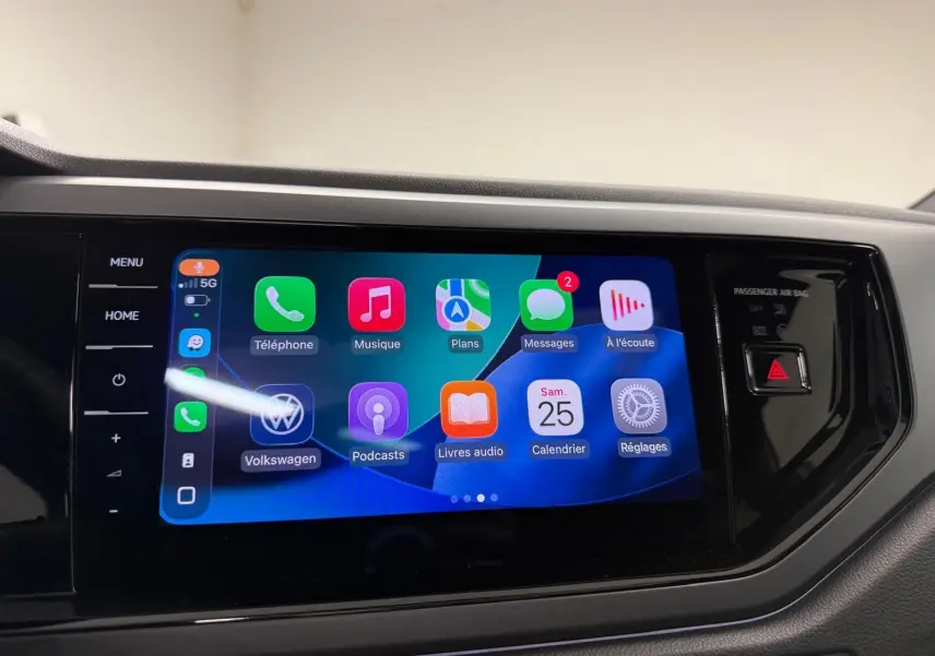 Écran tactile central du Volkswagen Taigo 2025 affichant l'interface Apple CarPlay avec commandes tactiles latérales.