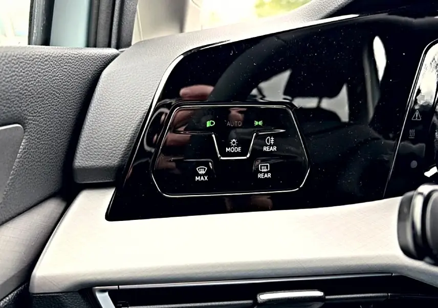 Détail du panneau de commandes d’éclairage intérieur noir brillant sur tableau de bord clair d’une Volkswagen Golf 2026.