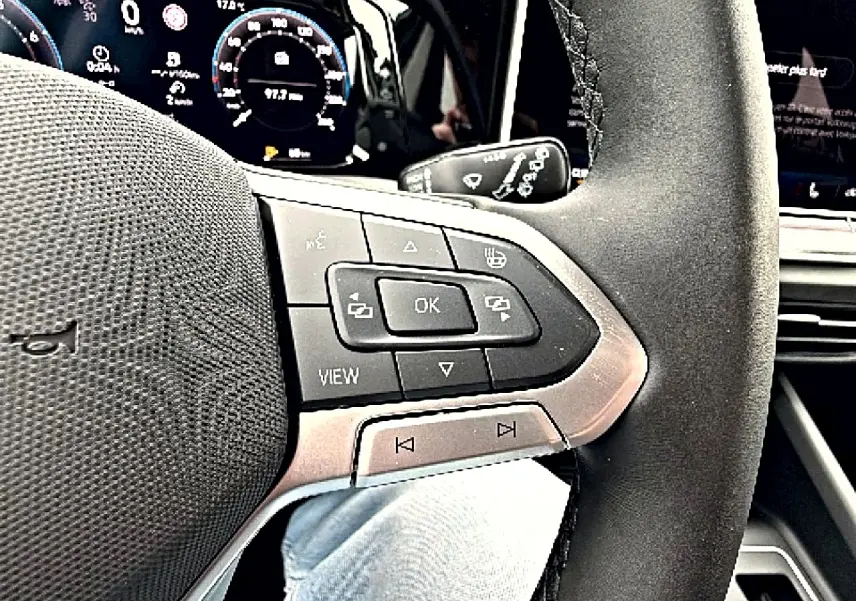 Gros plan sur le volant noir avec commandes multifonctions et tableau de bord digital de la Volkswagen Golf 2026.