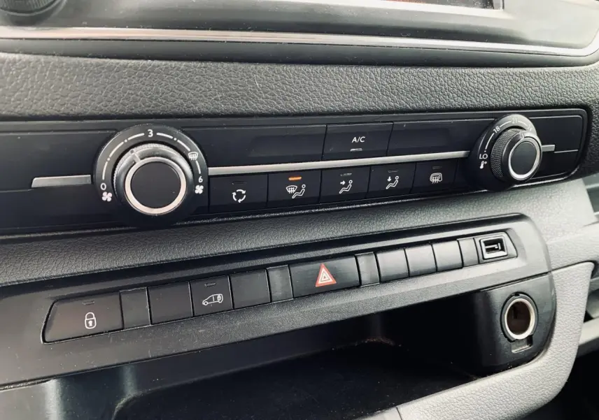 Détail de la console centrale noire avec commandes climatisation et boutons multifonctions du Citroën Jumpy XL blanc 2020.