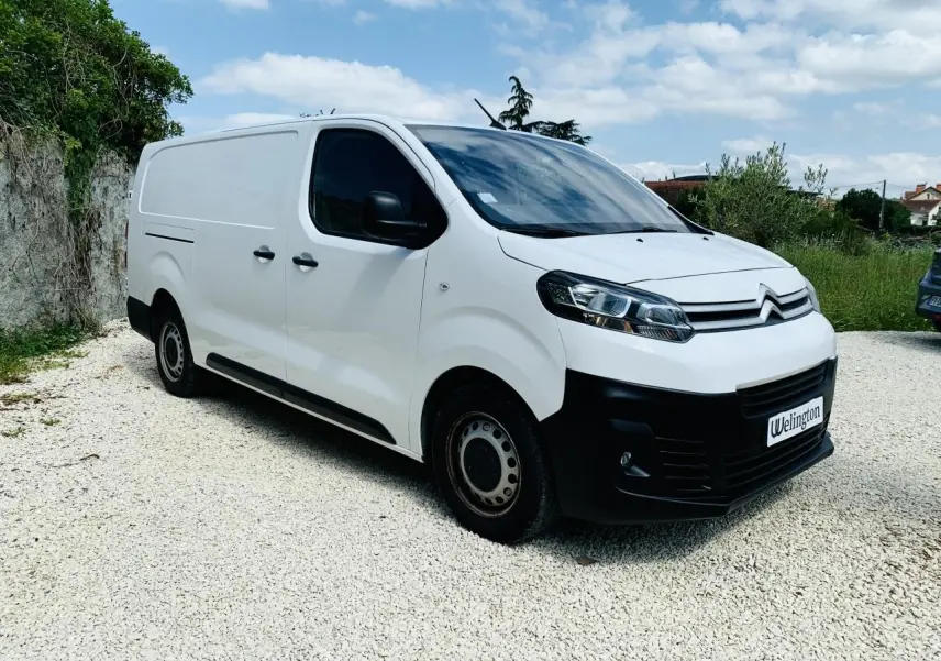 Fourgon Citroën Jumpy XL blanc vu en 3/4 avant droit, avec calandre noire et jantes acier sur sol gravillonné.