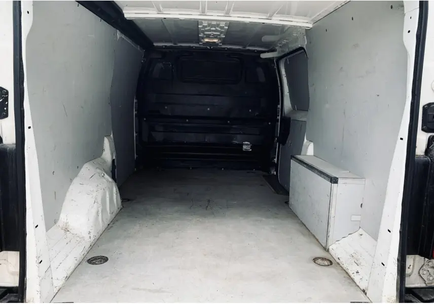 Vue intérieure de l'espace de chargement blanc du Citroën Jumpy XL 2020 avec cloison tôlée et anneaux d'arrimage.