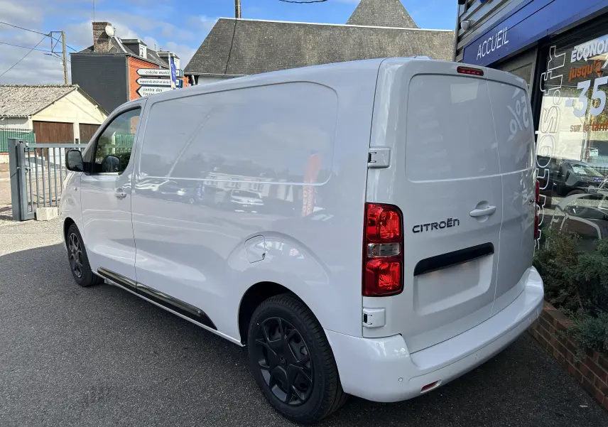 Vue 3/4 arrière droite d'un Citroën Jumpy Fourgon blanc de 2025 avec feux arrière rouges et jantes noires.