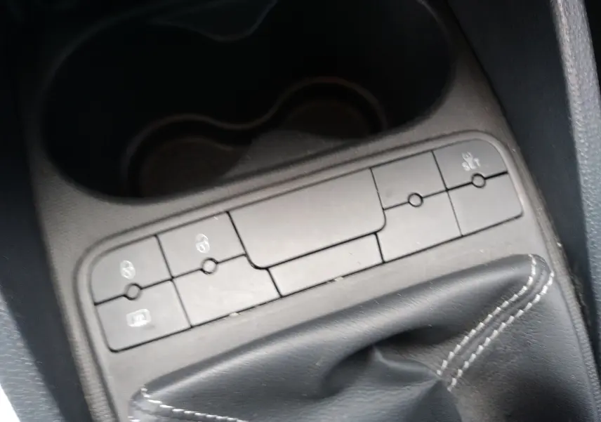 Gros plan sur la console centrale d'une SEAT Ibiza ST rouge, mettant en valeur le levier de vitesse manuel et les boutons de commande.