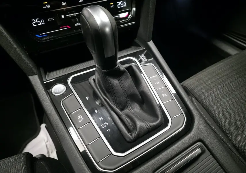 Le levier de vitesse automatique noir de la Volkswagen Passat SW 2021 vu de dessus avec console et sièges en tissu gris.