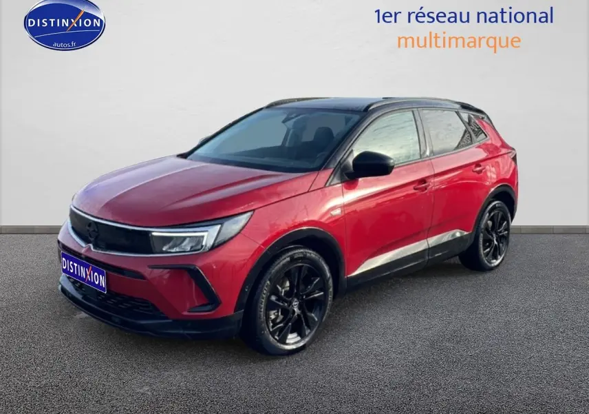 Opel Grandland rouge 3/4 avant droit avec toit noir et jantes alliage noires sur fond neutre.