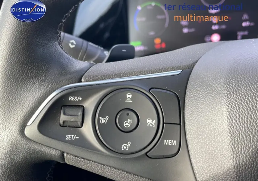 Gros plan sur les commandes multifonctions à gauche du volant de l’Opel Grandland rouge hybride 2024.
