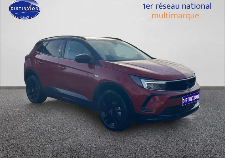 Opel Grandland rouge 3/4 avant droit avec jantes noires et feux LED modernes sur fond neutre.