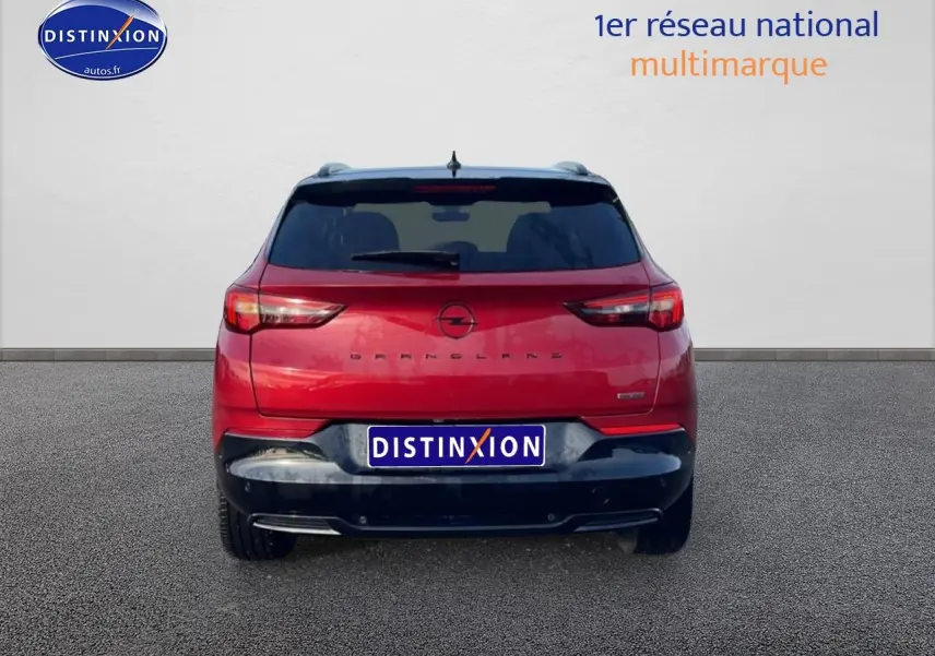 Vue arrière d'un Opel Grandland rouge 2024 avec feux LED et becquet noir sur fond neutre.