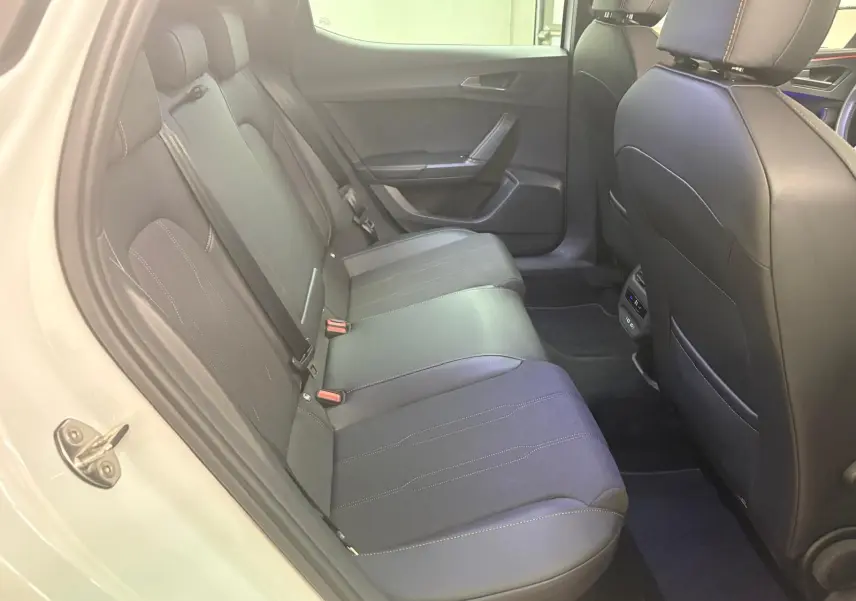 Vue intérieure côté gauche des sièges arrière en cuir noir du CUPRA Leon blanc Nevada 2024 avec toit ouvrant panoramique.