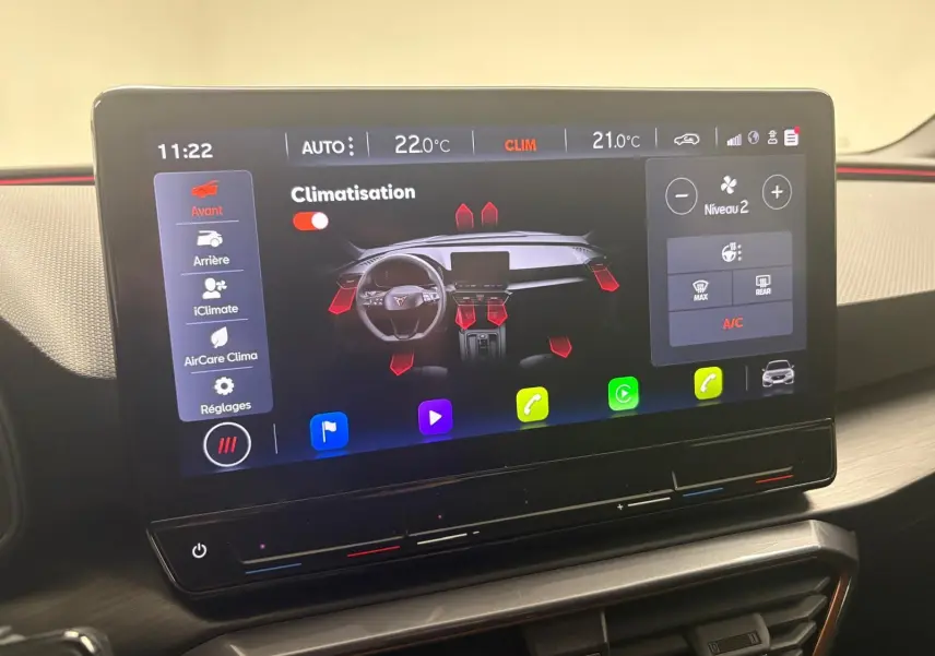 Écran tactile central affichant la climatisation du CUPRA Leon blanc Nevada, vue intérieure du tableau de bord.