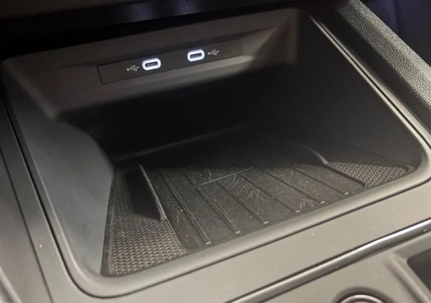 Gros plan sur le compartiment de rangement noir avec deux ports USB-C éclairés dans une CUPRA Leon 2024.