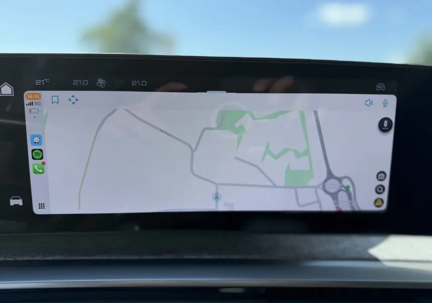 Écran tactile de navigation intérieur du Peugeot 5008 Hybrid 145 GT, affichant une carte et des icônes d'applications.