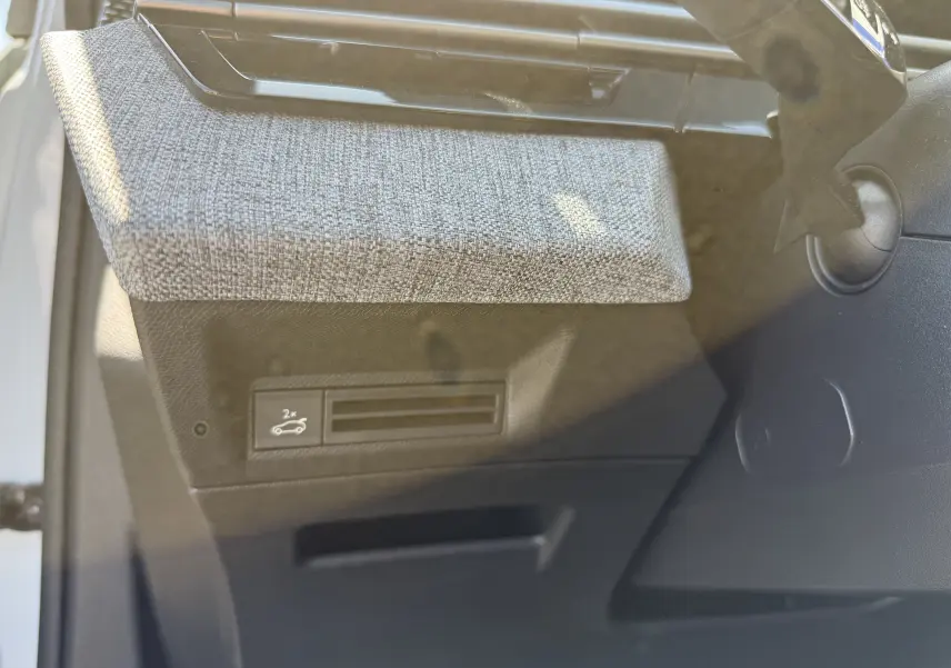 Détail intérieur du Peugeot 5008 Hybrid 145 GT montrant la texture grise du tableau de bord côté conducteur.