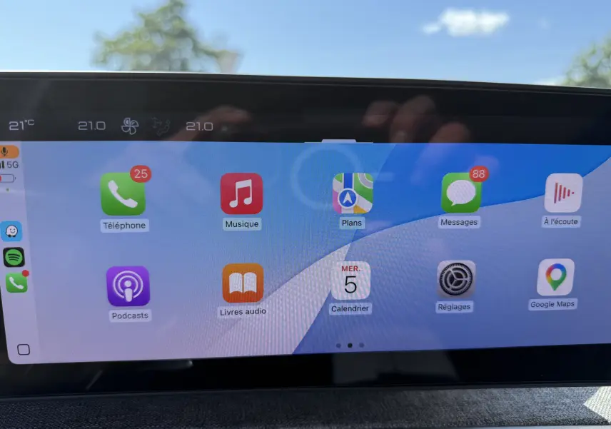 Écran tactile central du Peugeot 5008 Hybrid 145 GT 2025 affichant Apple CarPlay en plein jour.