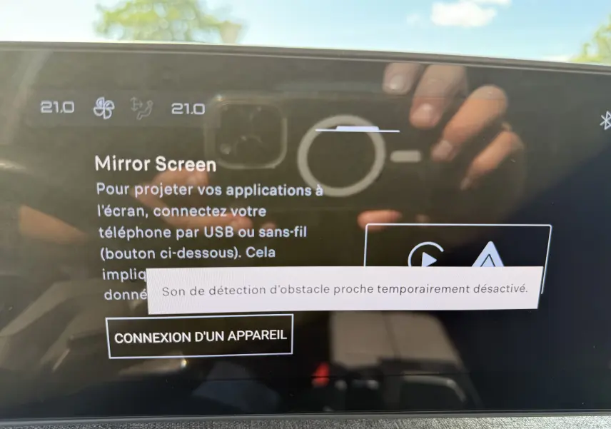 Écran tactile intérieur du Peugeot 5008 Hybrid 145 GT affichant l'option Mirror Screen avec reflet du photographe.