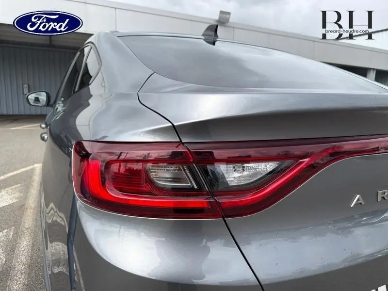 Gros plan sur le feu arrière droit d'une Renault Arkana gris métallisé, soulignant la ligne fluide du hayon arrière.