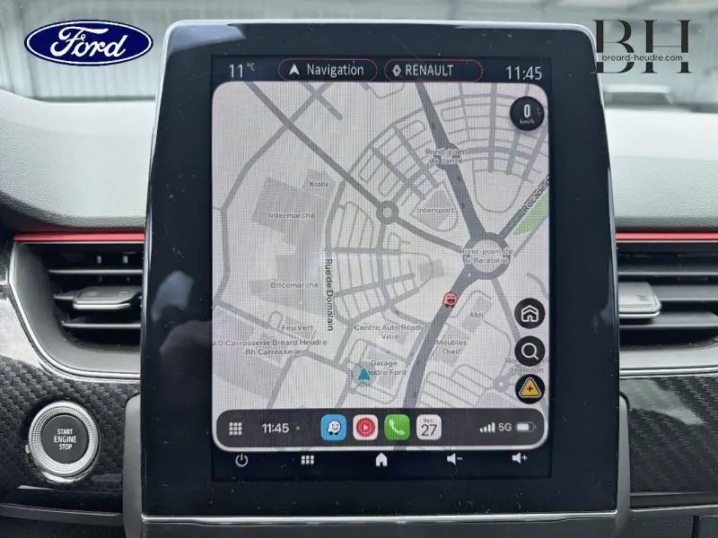 Tableau de bord avec écran tactile central affichant la navigation, entouré de garnitures noires et rouges.