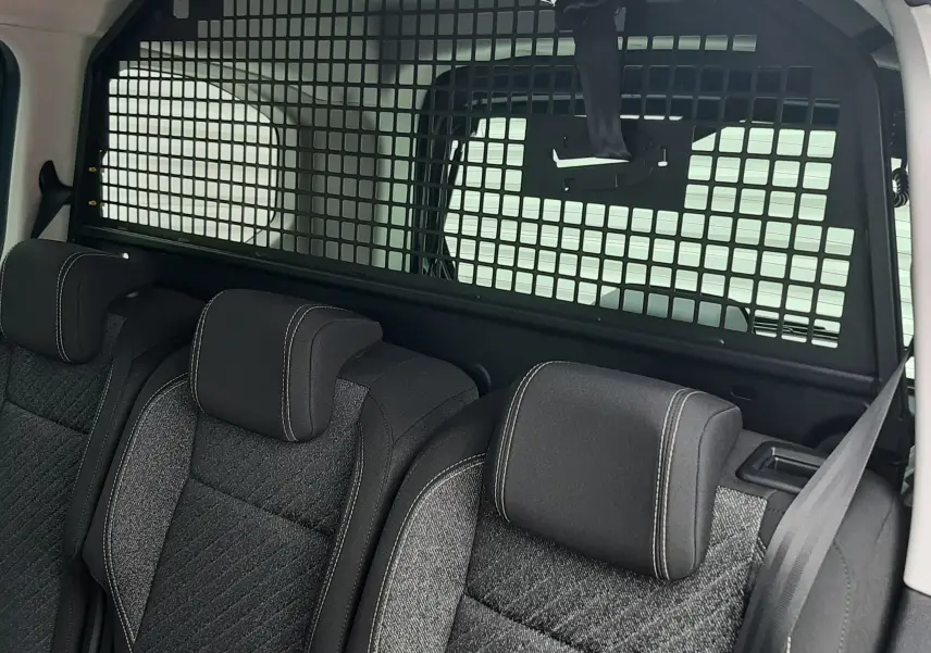 Vue intérieure arrière du Peugeot Rifter avec banquette tissu gris et séparation grillagée entre l'habitacle et la zone de chargement.