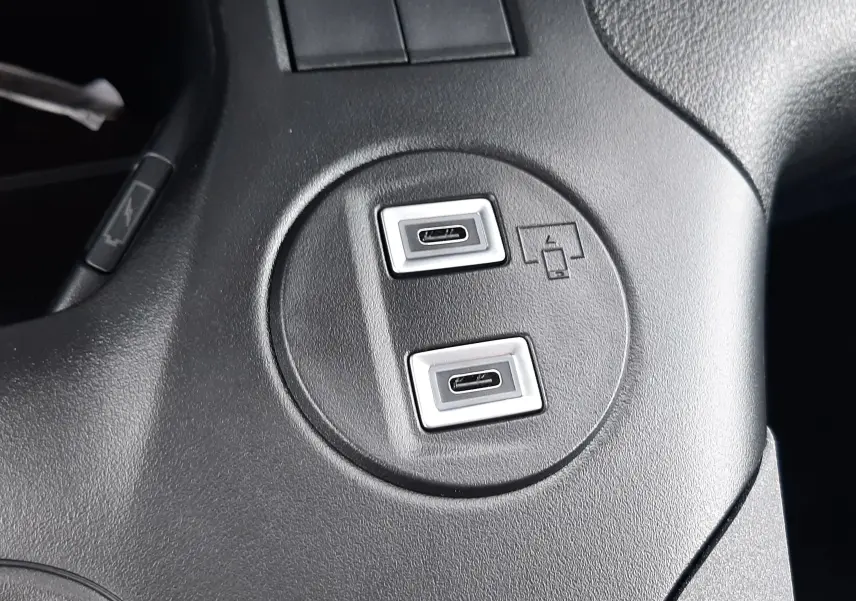 Gros plan sur deux ports USB-C intégrés dans la console centrale noire du Peugeot Rifter bleu Kiama 2026.