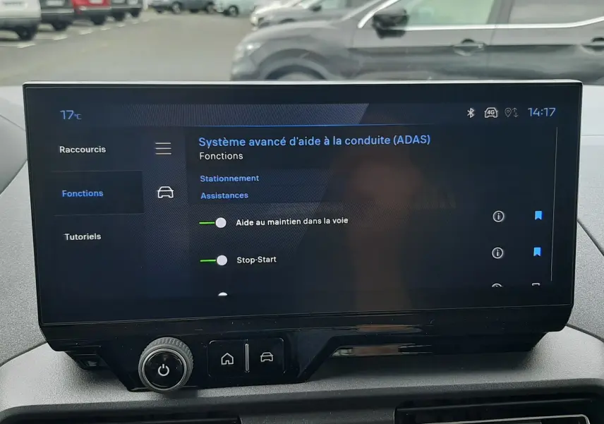Vue intérieure du tableau de bord du Peugeot Rifter 2026, écran tactile affichant les aides à la conduite, ambiance grise.