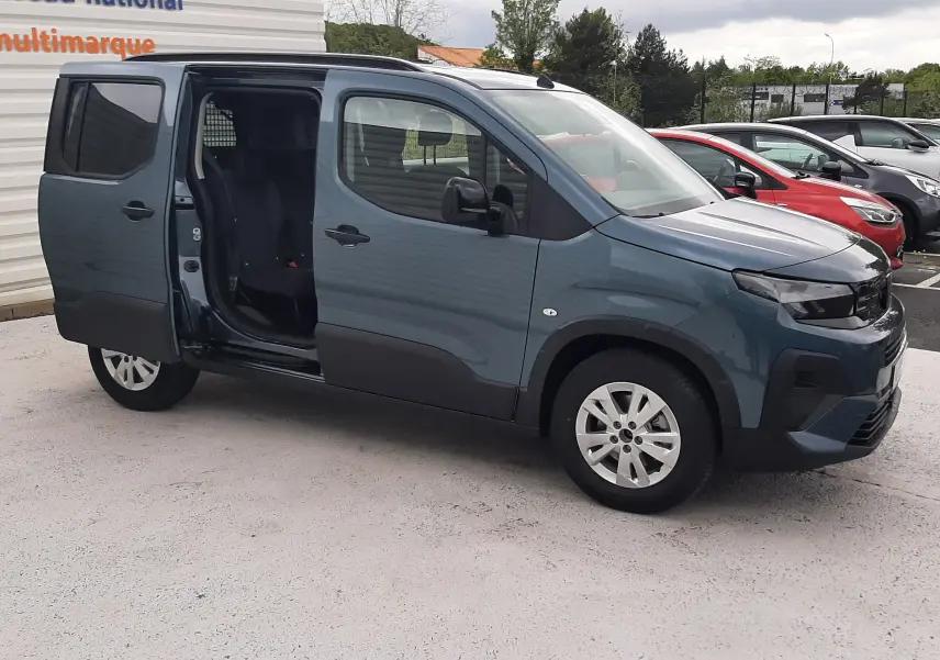 Peugeot Rifter bleu Kiama vue 3/4 avant droit avec porte coulissante arrière ouverte sur parking.