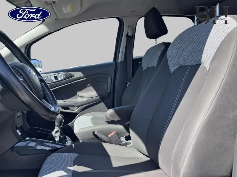 Vue intérieure côté conducteur du Ford EcoSport 1.5 TDCi 2016, sièges tissu noir et gris avec volant cuir multifonction.