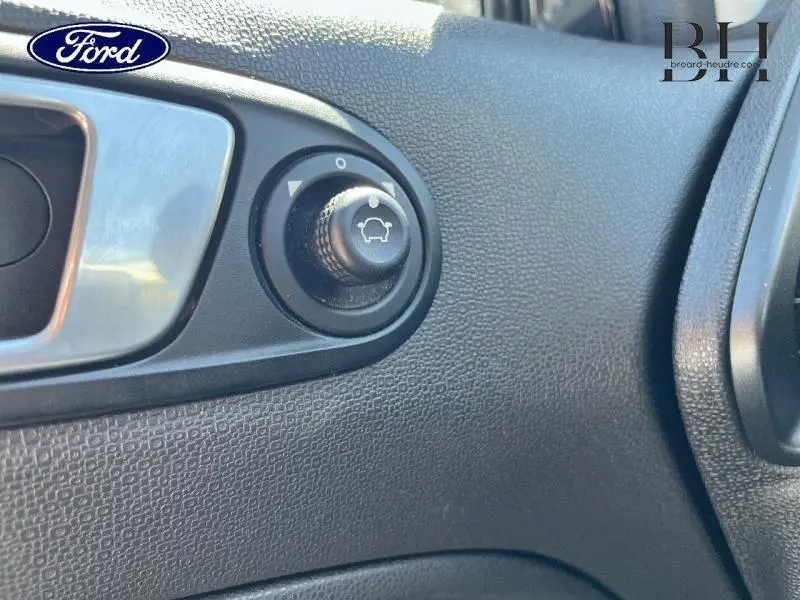 Détail du bouton de réglage des rétroviseurs côté conducteur dans l'habitacle noir du Ford Ecosport 2016.