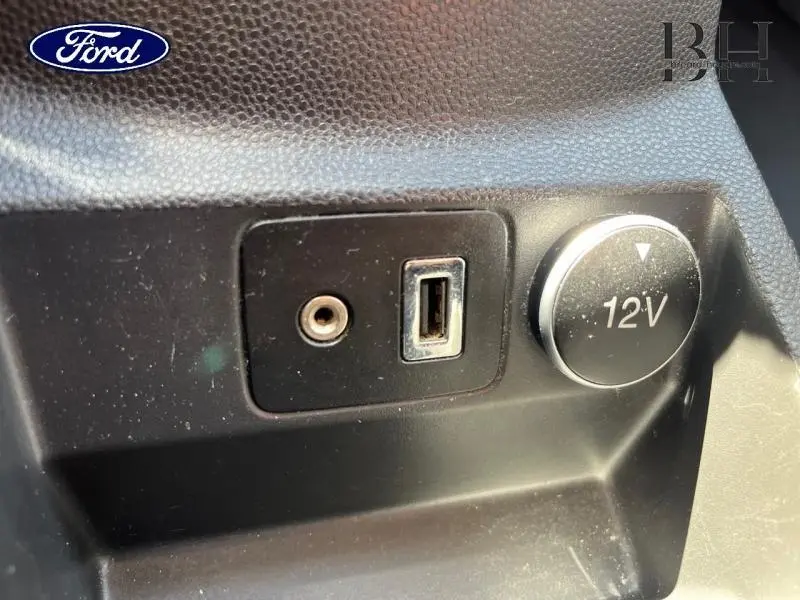 Prise 12V, port USB et entrée auxiliaire dans l'habitacle du Ford EcoSport noir Scala, vue rapprochée du tableau de bord.