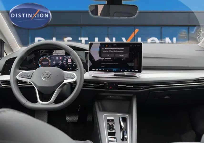 Vue intérieure avant centrée sur le tableau de bord et volant gris d’une Volkswagen Golf 2026 avec écran tactile et digital cockpit.