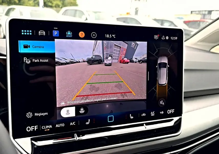 Écran tactile intérieur affichant la caméra de recul et l’assistance au stationnement de la Volkswagen Golf noire.