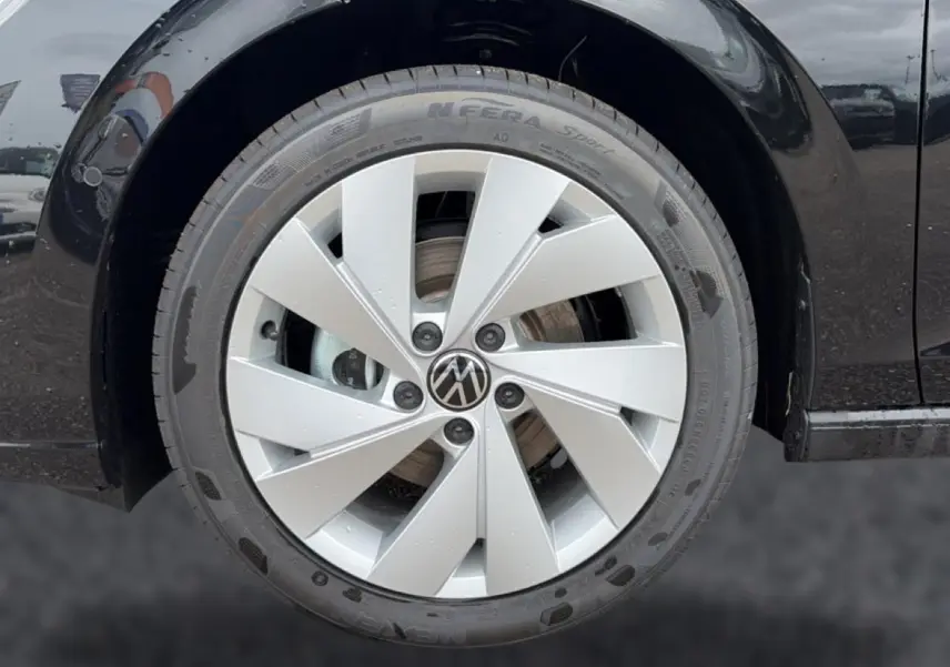 Gros plan sur la roue avant droite d’une Volkswagen Golf noire avec jante alu 17 pouces au design moderne.