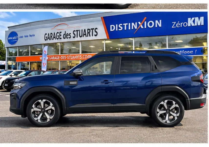 Vue de profil côté gauche du Dacia Bigster 2026 en bleu indigo, avec roues alliage et protections noires sur les passages de roue.