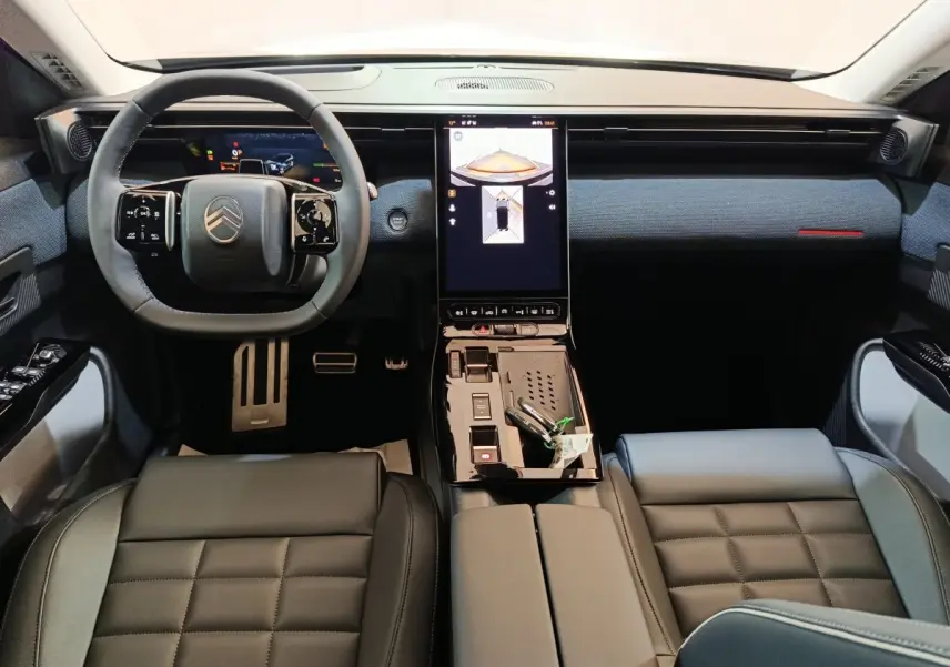 Vue intérieure avant du Citroën C5 Hybride 2026, tableau de bord moderne avec écran tactile central vertical et volant cuir noir.