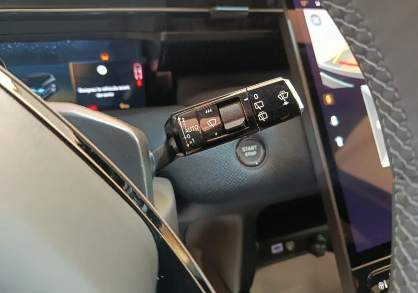 Gros plan sur la commande d’essuie-glace à gauche du volant dans l’habitacle noir du Citroën C5 Hybride 2026.