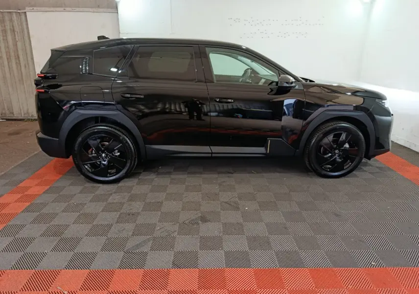 Profil côté gauche d'un Citroën C5 Hybride noir 2026 avec jantes noires et détails de carrosserie anguleux.