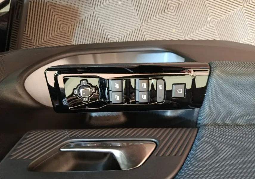 Gros plan sur la commande de lève-vitres et verrouillage côté conducteur de la Citroën C5 Hybride 2026 noire.