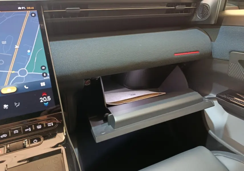 Intérieur de la Citroën C5 Hybride 2026, vue du tableau de bord côté passager avec boîte à gants ouverte et écran tactile visible.