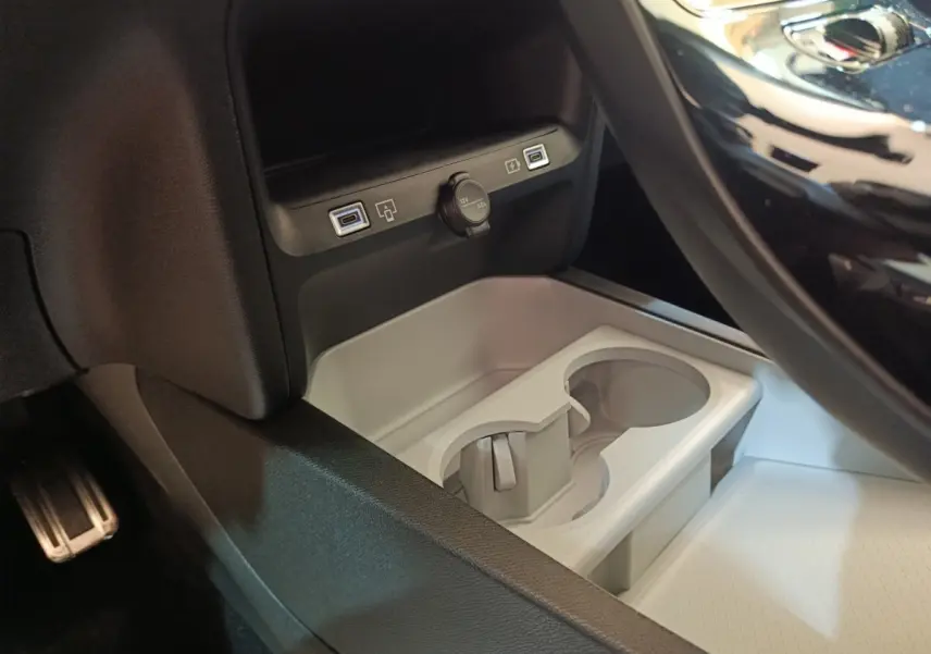 Gros plan sur la console centrale noire de la Citroën C5 Hybride, avec prises USB et prise 12V visibles.